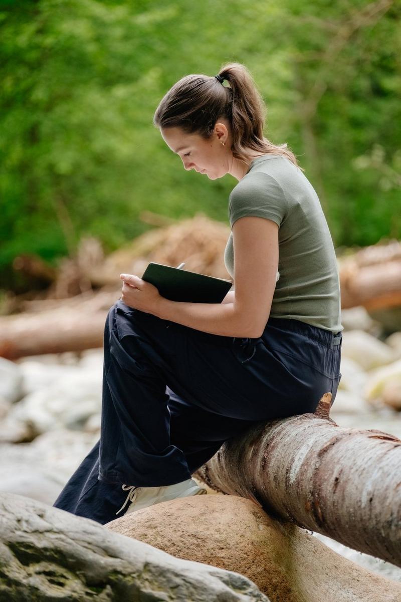 Woman in nature writing in her journal